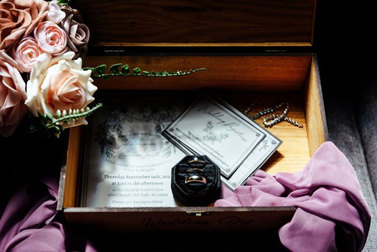 a keepsake box of the wedding couple with their rings, invitations, and flowers.