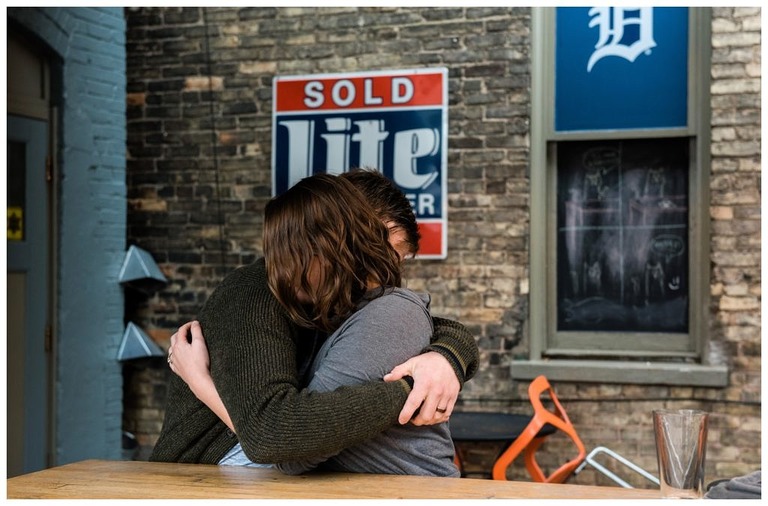 a couple hugging with a detroit tiger's sign