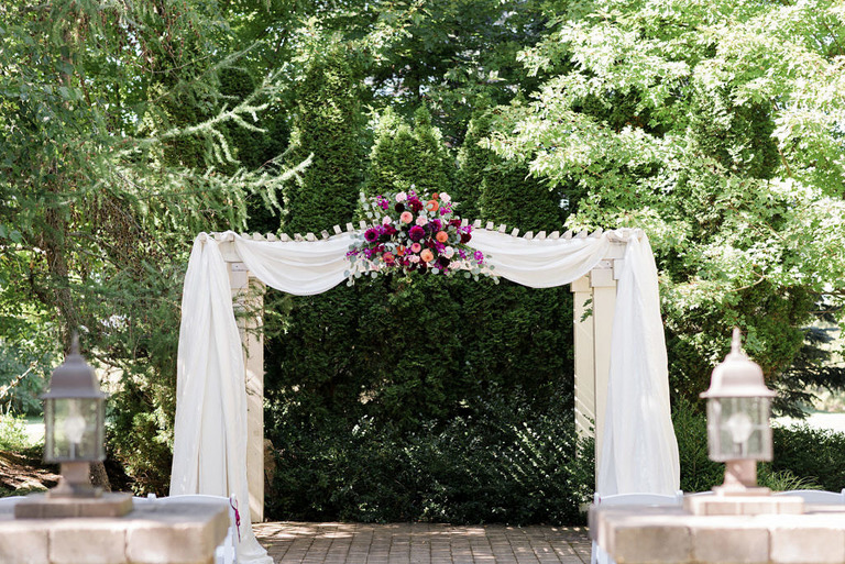 a wooded background with a draped arch at fox hill event center