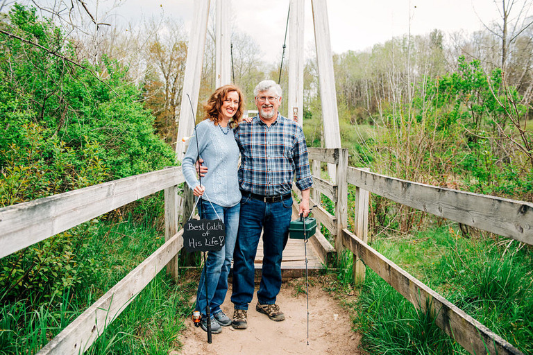 a couple smiling on the suspension bridge over the Manistee River