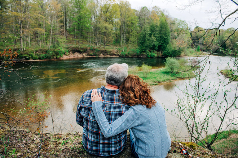 A couple sitting on the bank of the Manistee River