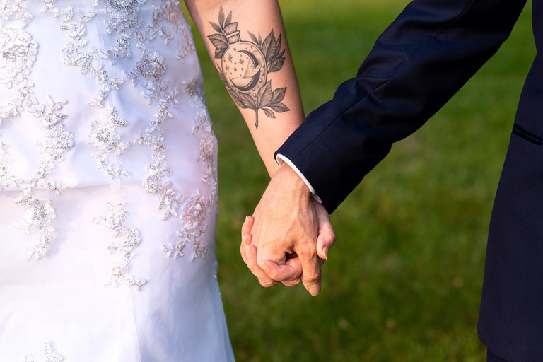 a bride with a time piece tattoo on her forearm