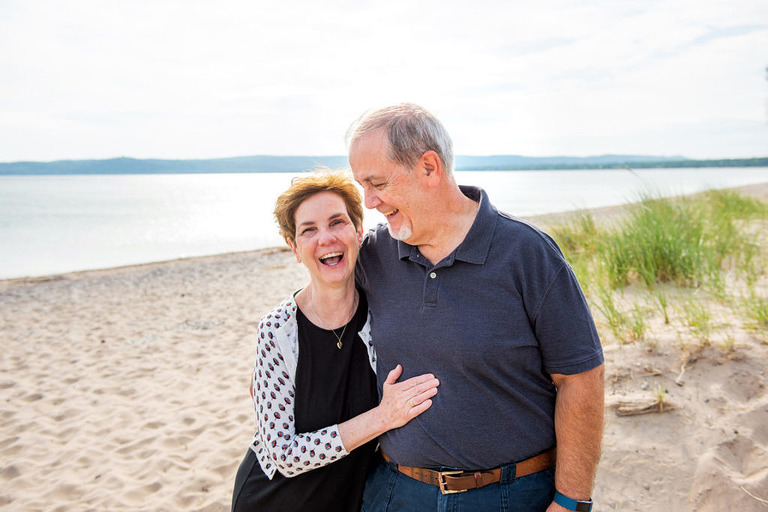 a laughing couple on the shore at Glen Haven