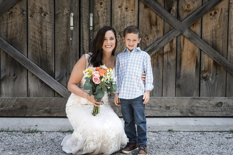 wedding mother and son in front of barn doors at Iron Fish Distillery