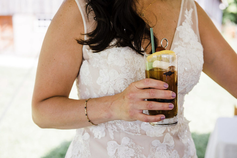 bride holding cocktail at Iron Fish Distillery