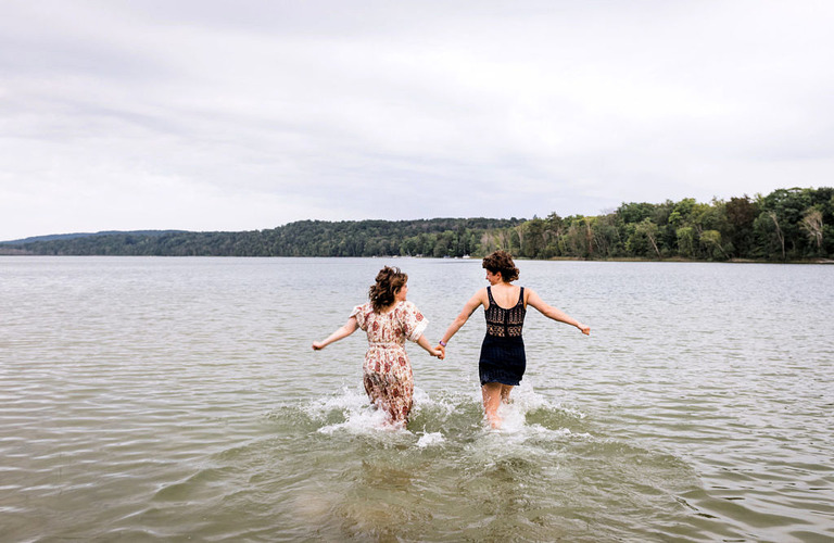two women holding hands and running into the lake at Labrys resort