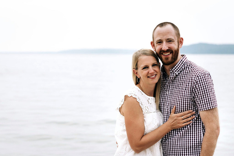 husband and wife smiling at crystal lake