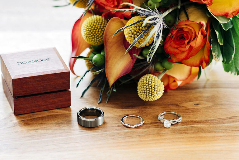 wedding rings with bright orange and yellow flowers