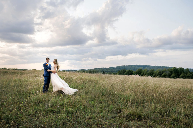 dramatic clouds and wind make a beautiful backdrop for a wedding couple