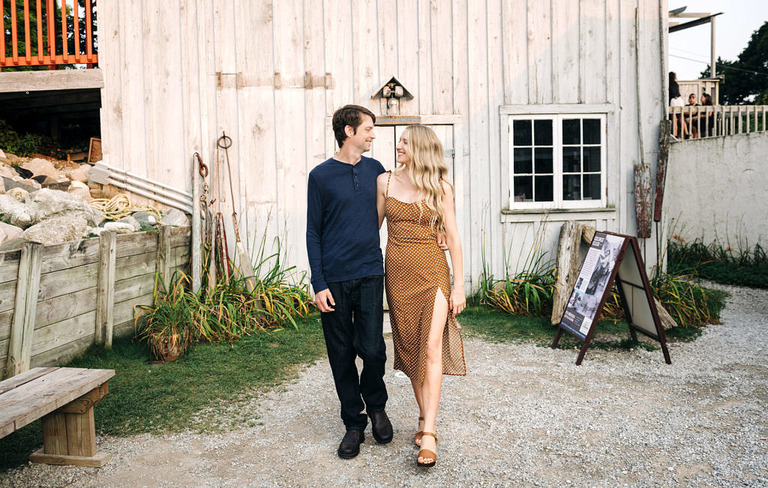 a couple walking from a rustic barn door