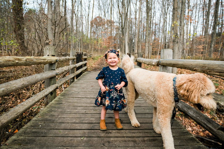 little girl with blonde golden doodle