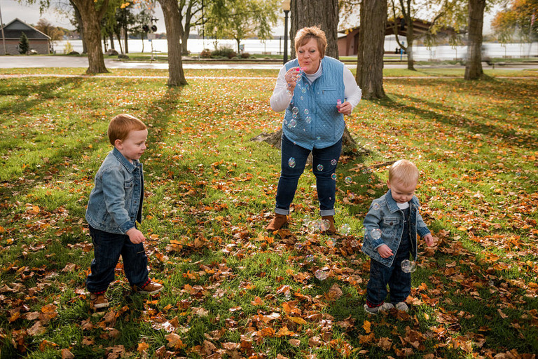 a grandma and two little boys play at the old train depot
