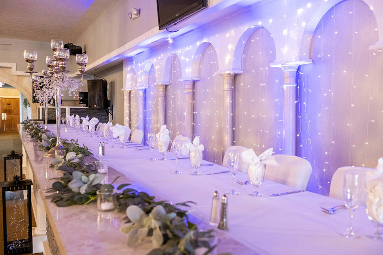 head table at a wedding with blue uplights