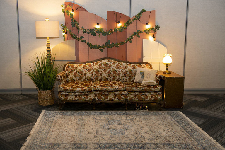 a vintage couch and carpet for a wedding photobooth