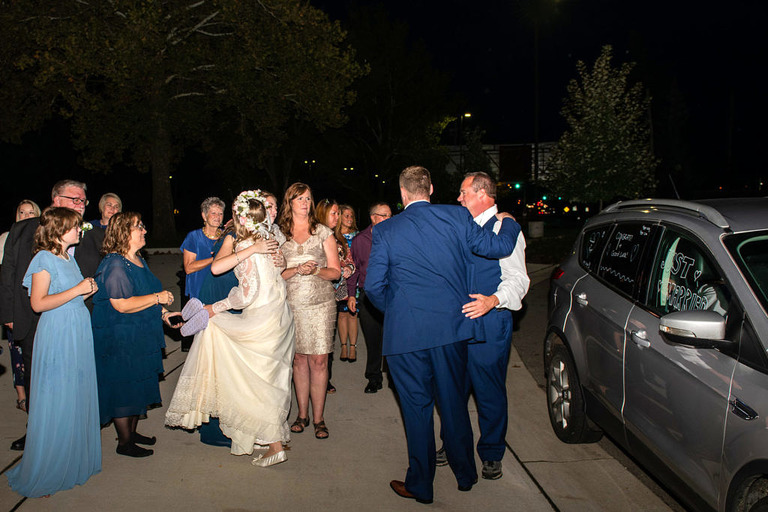 parents hugging the wedding couple as they exit