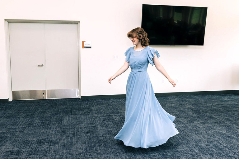 a girl spins in a blue dress