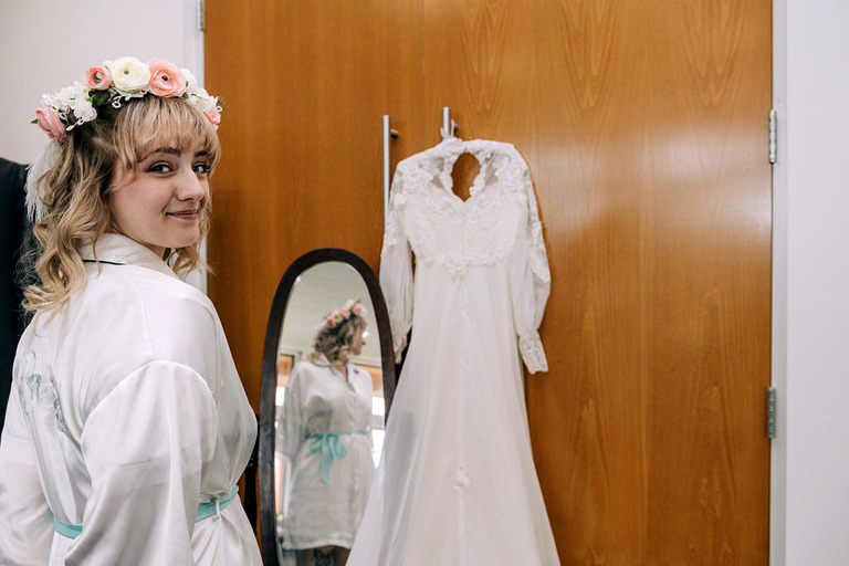 a bride and her dress with a vintage mirror