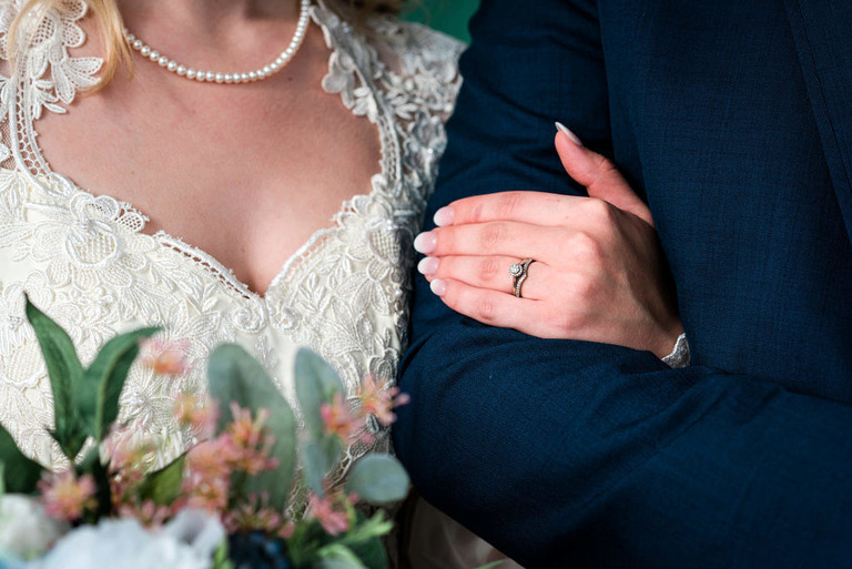 close up of bride and grooms arms and rings