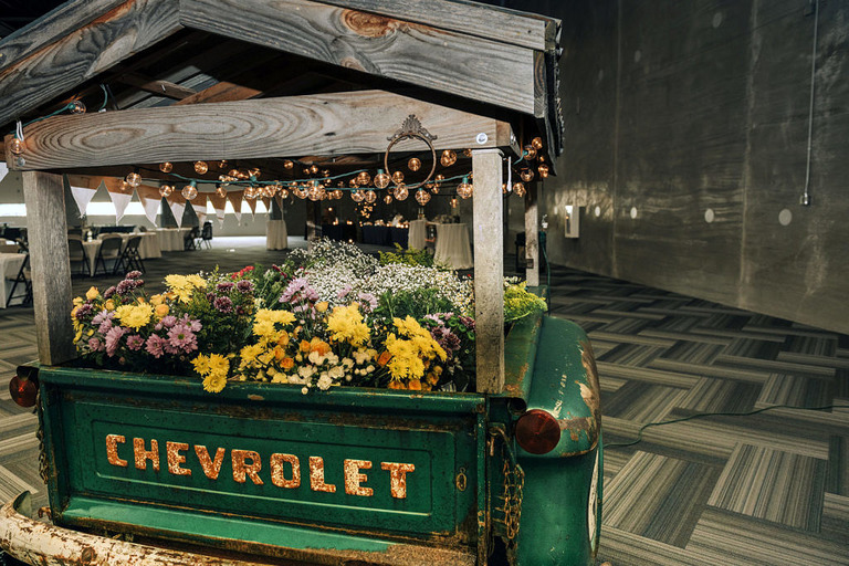 the vintage tail end of a chevy truck turned into a flower cart at a wedding