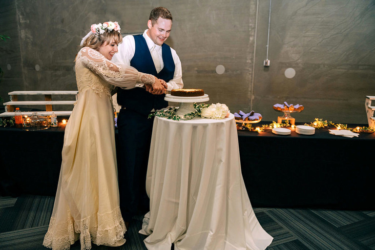bride and groom cut their cheesecake