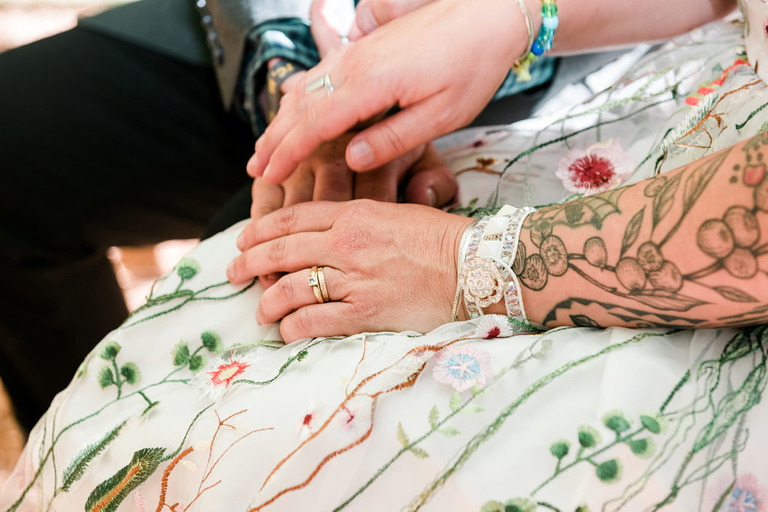 wedding rings on tattooed hands in traverse city