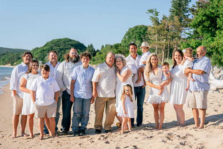 a large family poses together on the beach of lake MI