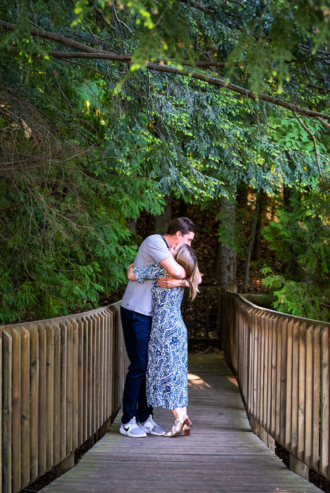 couple embracing on the bridge at boardman river nature trail