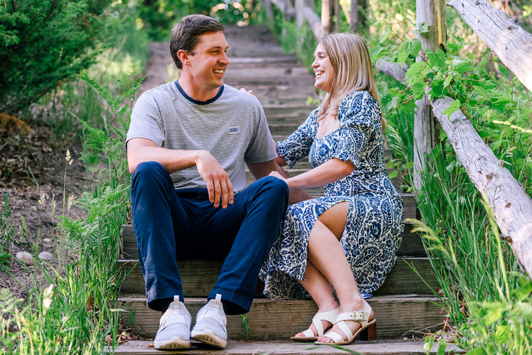 engagement photo of a couple seated and laughing