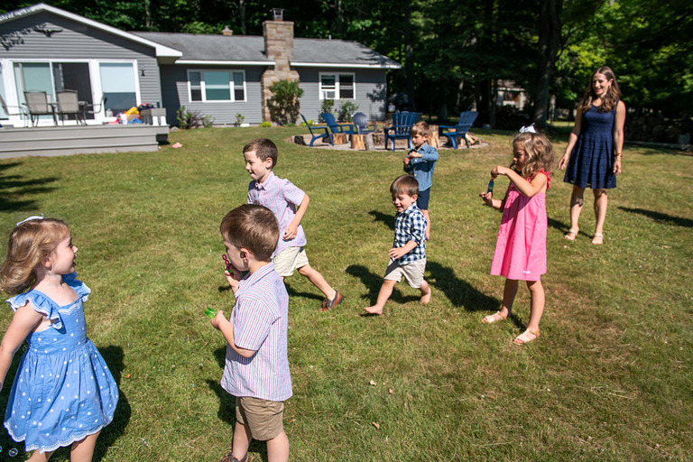 a group of small chi;ldren running and blowing bubbles