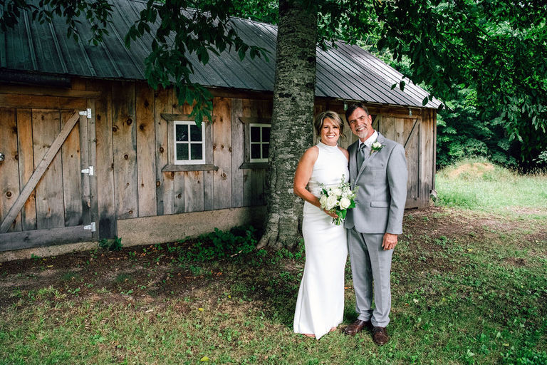 a-married- couple- stands-near-a-barn-at-Iron-Fish