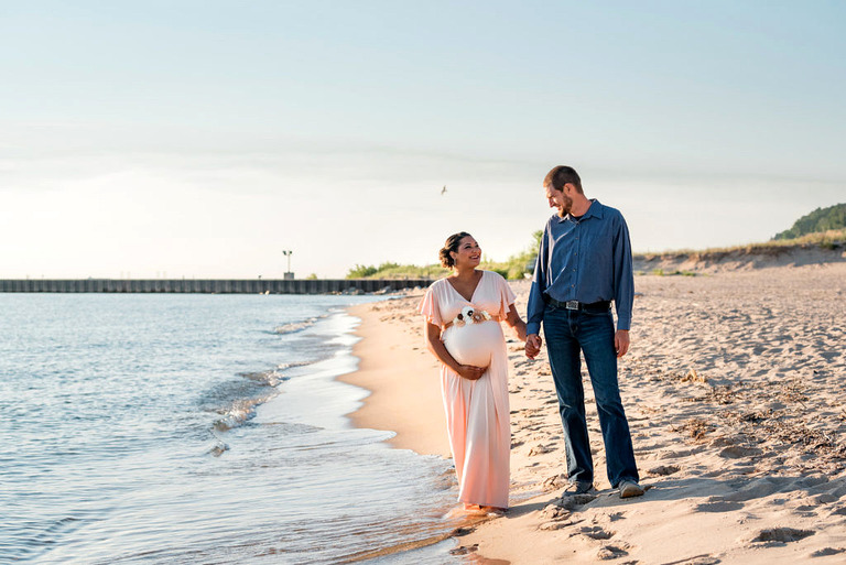 pregnancy-couple-walking-on-a-beach-in -Michigan