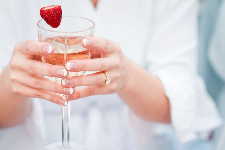 a glass of champagne with a strawberry and an engagement ring in Frankfort, MI.