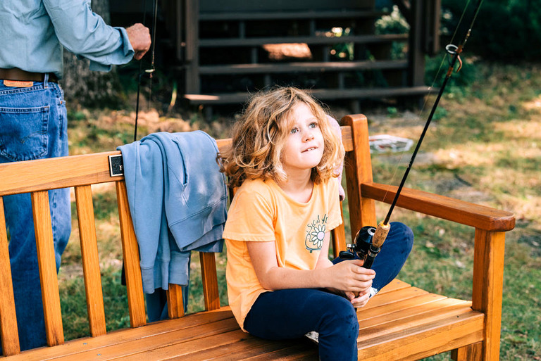 a little girl holds a fishing rod in Mesick.