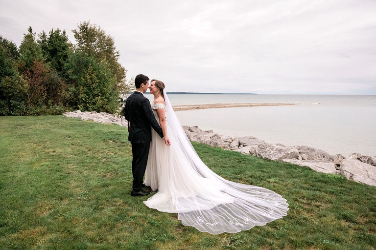 a wedding couple stands at the shore of the Headlands International Dark Sky park in Mackinaw City