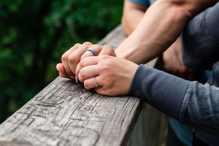 a couples hands are shown with engagement rings for their photos on the high rollaway trail.