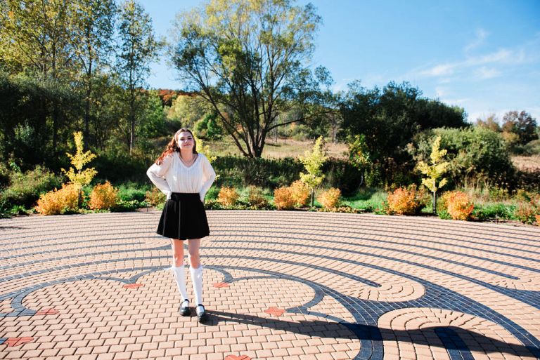 a picture of a girl posing for senior photos at the traverse city labyrinth.