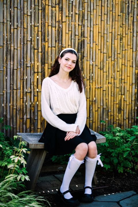 a graduating senior has her photos taken in the botanic garden in front of bamboo