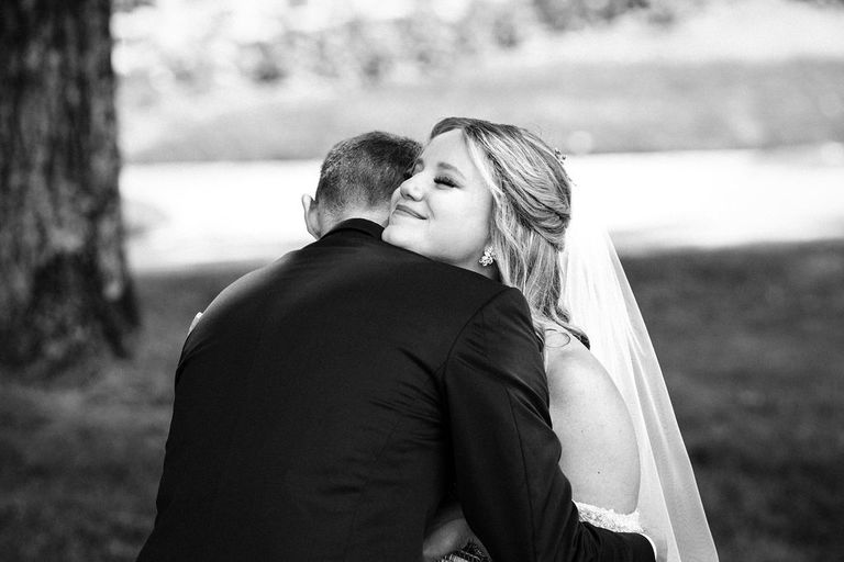 black and white photo of a wedding couple hugging.