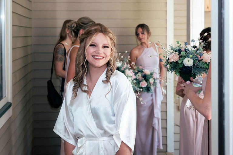bride surrounded by her bridesmaids while getting ready at the Homestead.