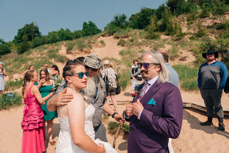The bride and groom greeting guests on Empire Bluff trail.