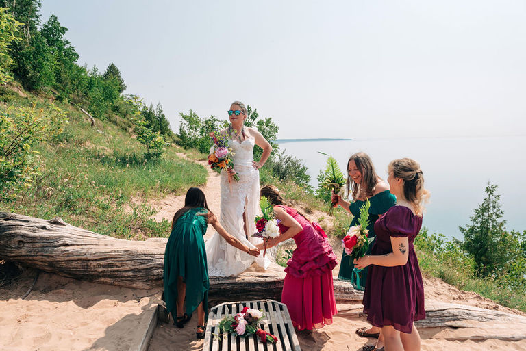 the bride poses as a modern day Goddess and her party attends to her at Empire bluffs.