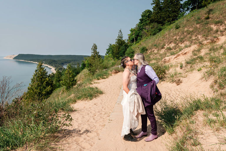 A wedding couple celebrates with a kiss at the head of Empire Bluffs trail.