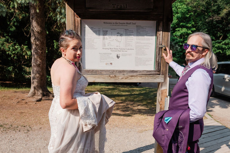 The wedding couple at the sign for the trail at sleeping bear dunes.
