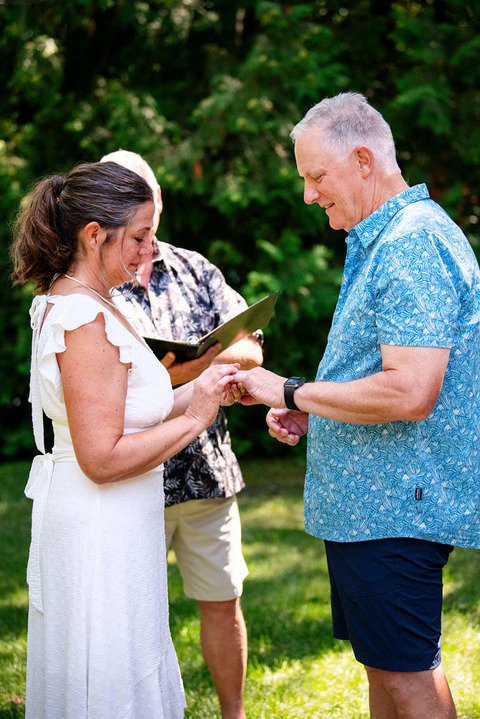 a couple exchanges rings at an Airbnb in a micro wedding in Leelanau.