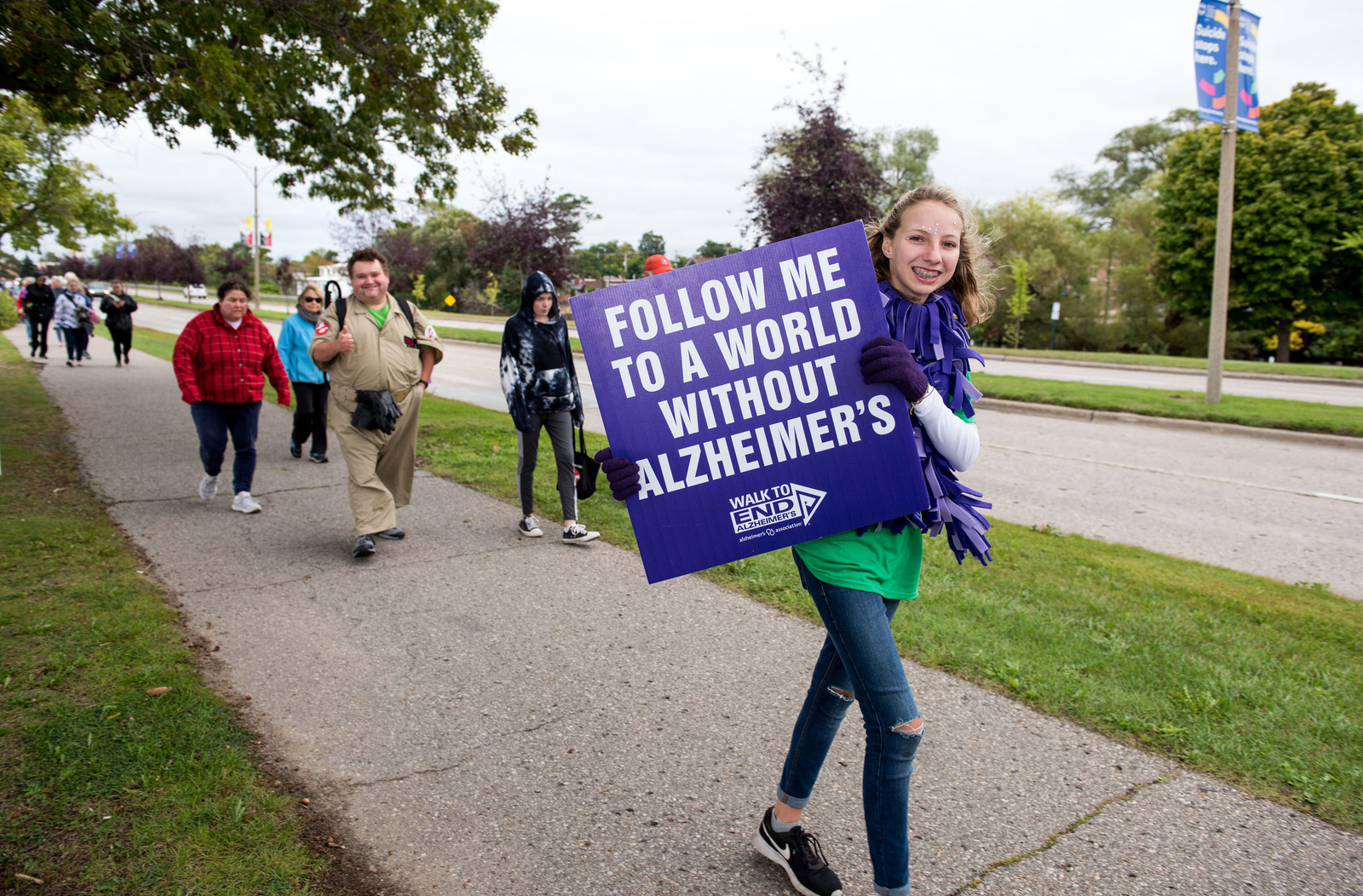 a volunteer at the #endalzheimers walk carrying a sign