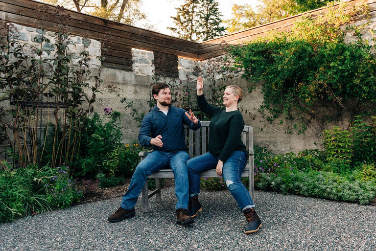 a couple acts like robots in the Traverse City Botanical gardens for engagement photos.