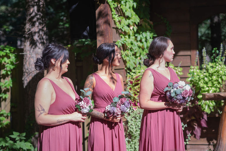 The bridesmaids in rose column dresses stad during the ceremony at Blue Bridge Events Center.