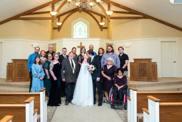 a large wedding family group photo inside the hawk hollow chaple at the Eagle Eye golfcourse.