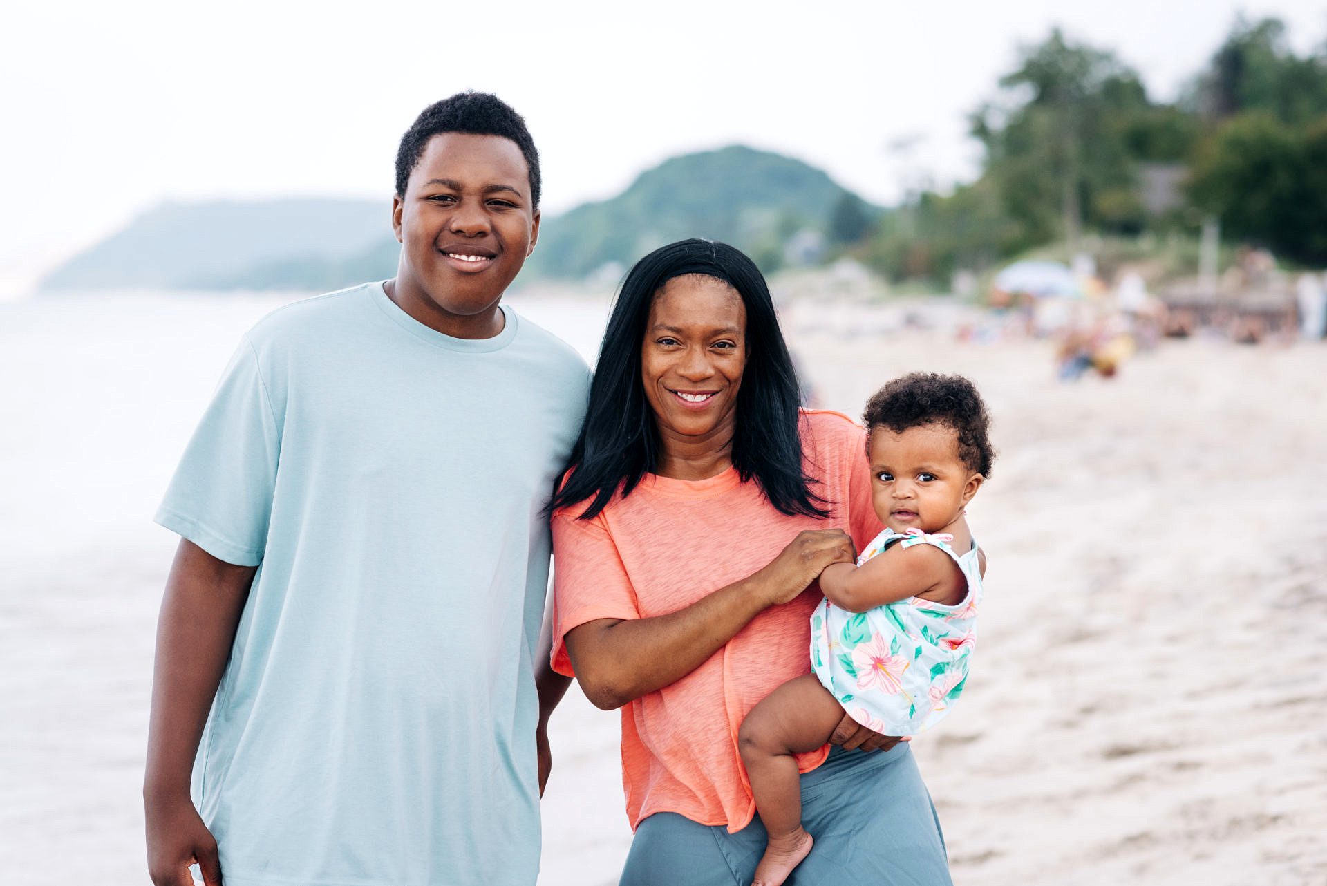 a mom and her two children at the beach in frankfort, michigan. Son is a teen. Daughter is a baby