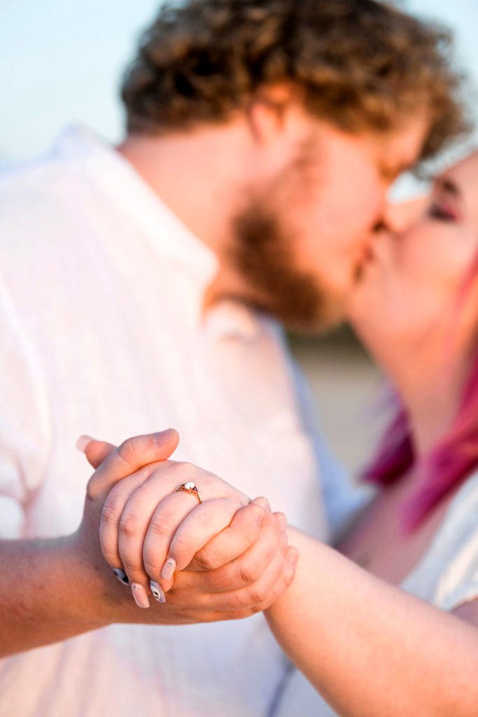 an engagement ring is the focus of this photo at Elberta beach Michigan.